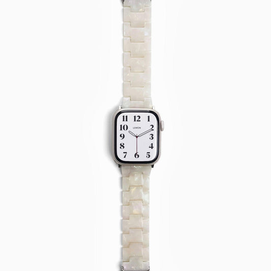 A pearl white resin band for Apple Watch, displayed on a watch with a silver case.