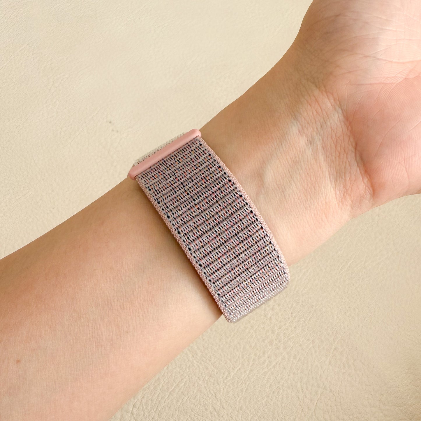 Wristband worn on a BAND APPLE WATCH against a beige background