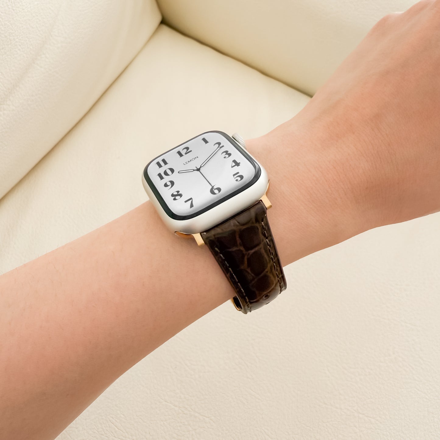 Wrist wearing a APPLE watch with a brown strap 