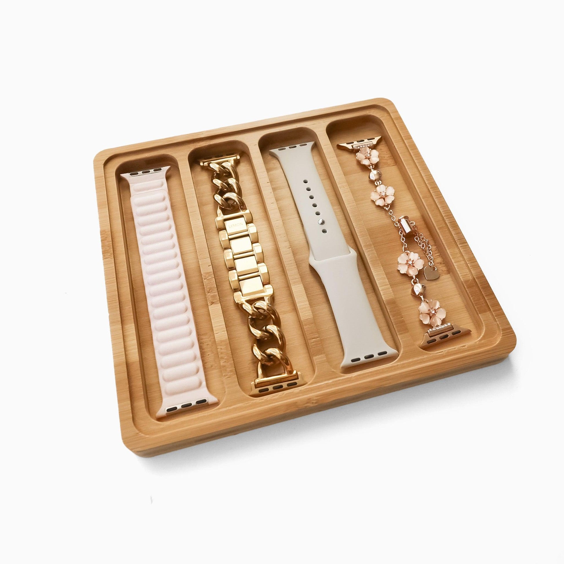 A bamboo watch band storage display box with four slots, containing various watch bands