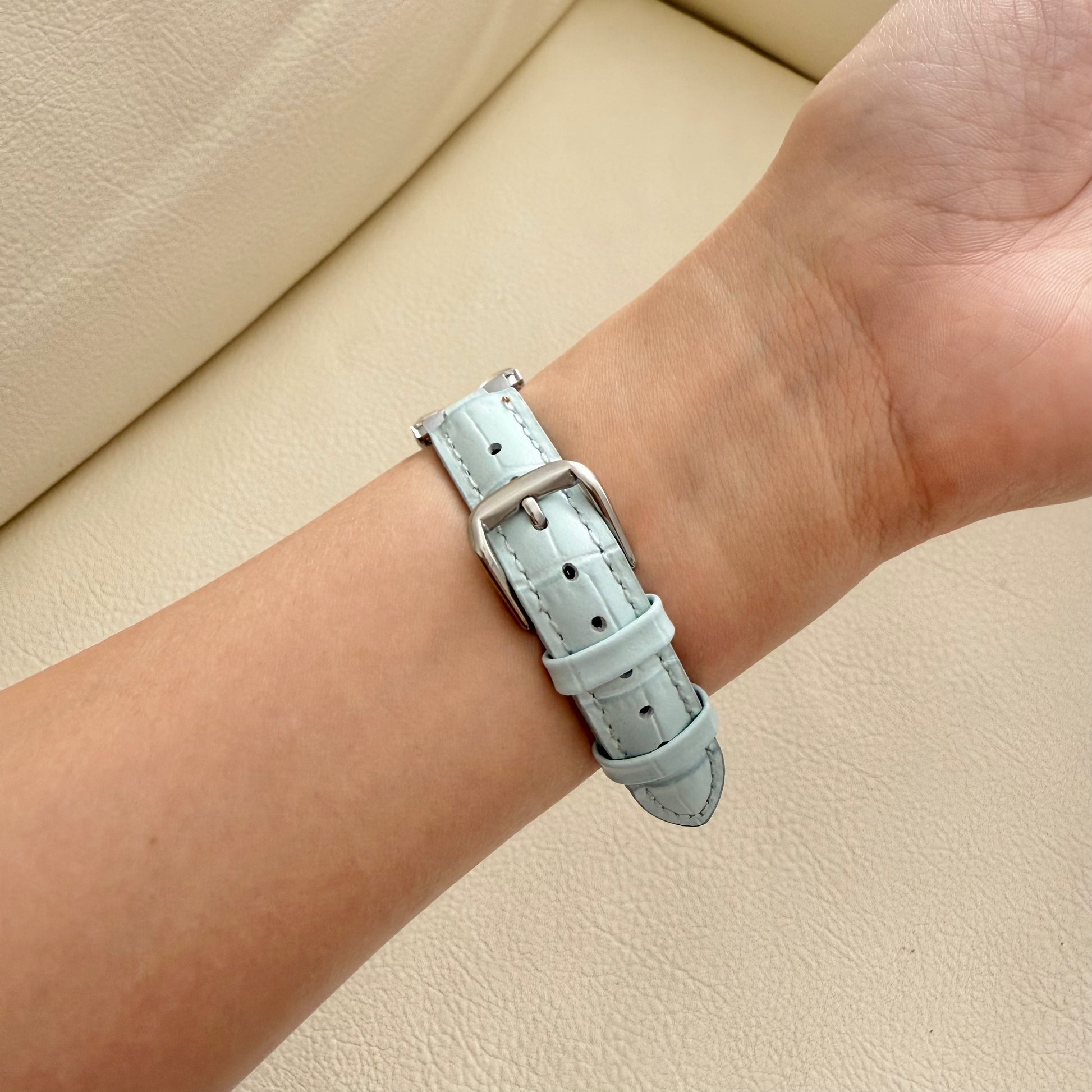 Light blue leather APPLE watch strap on a wrist 