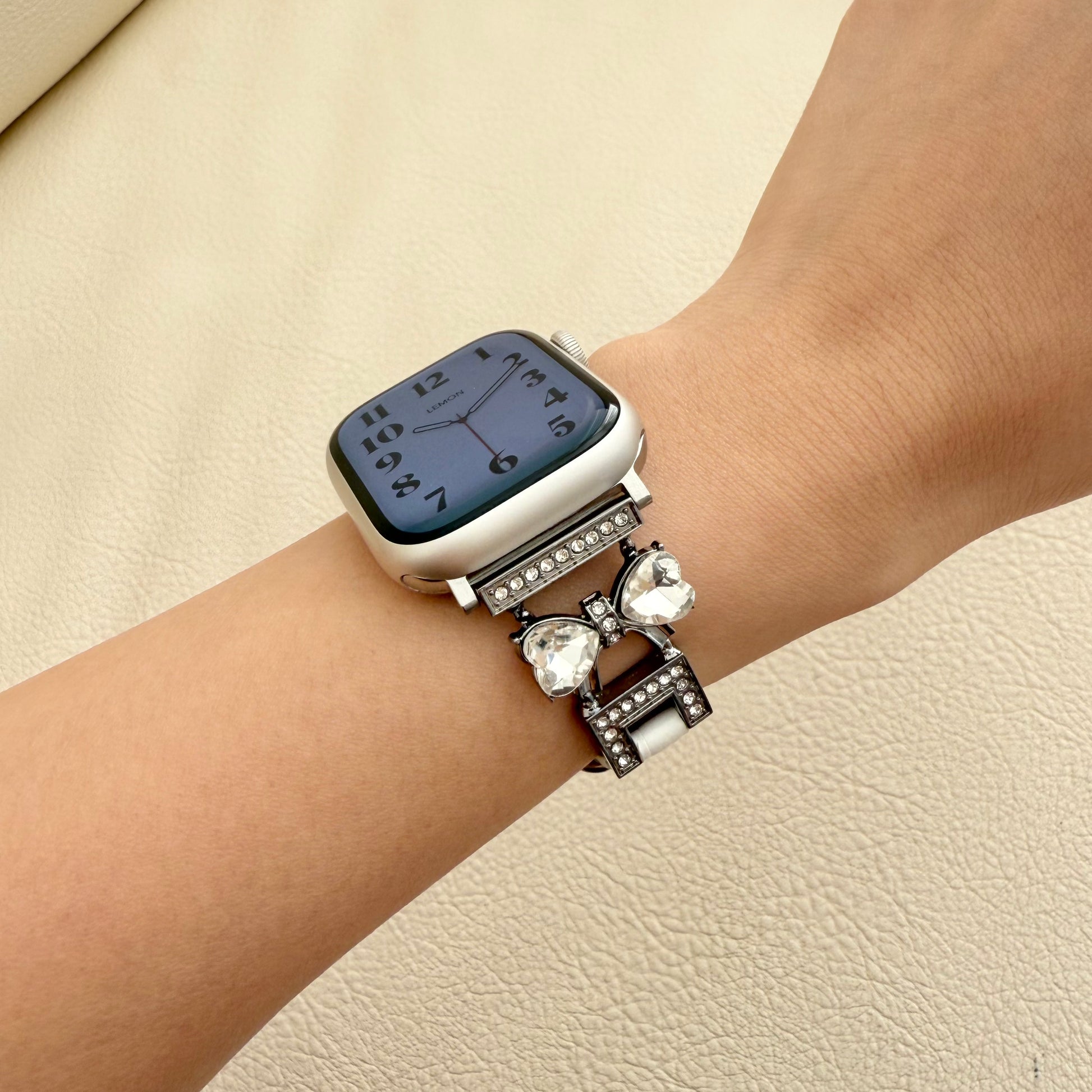 Silver smartwatch with decorative band featuring a bow and crystals 