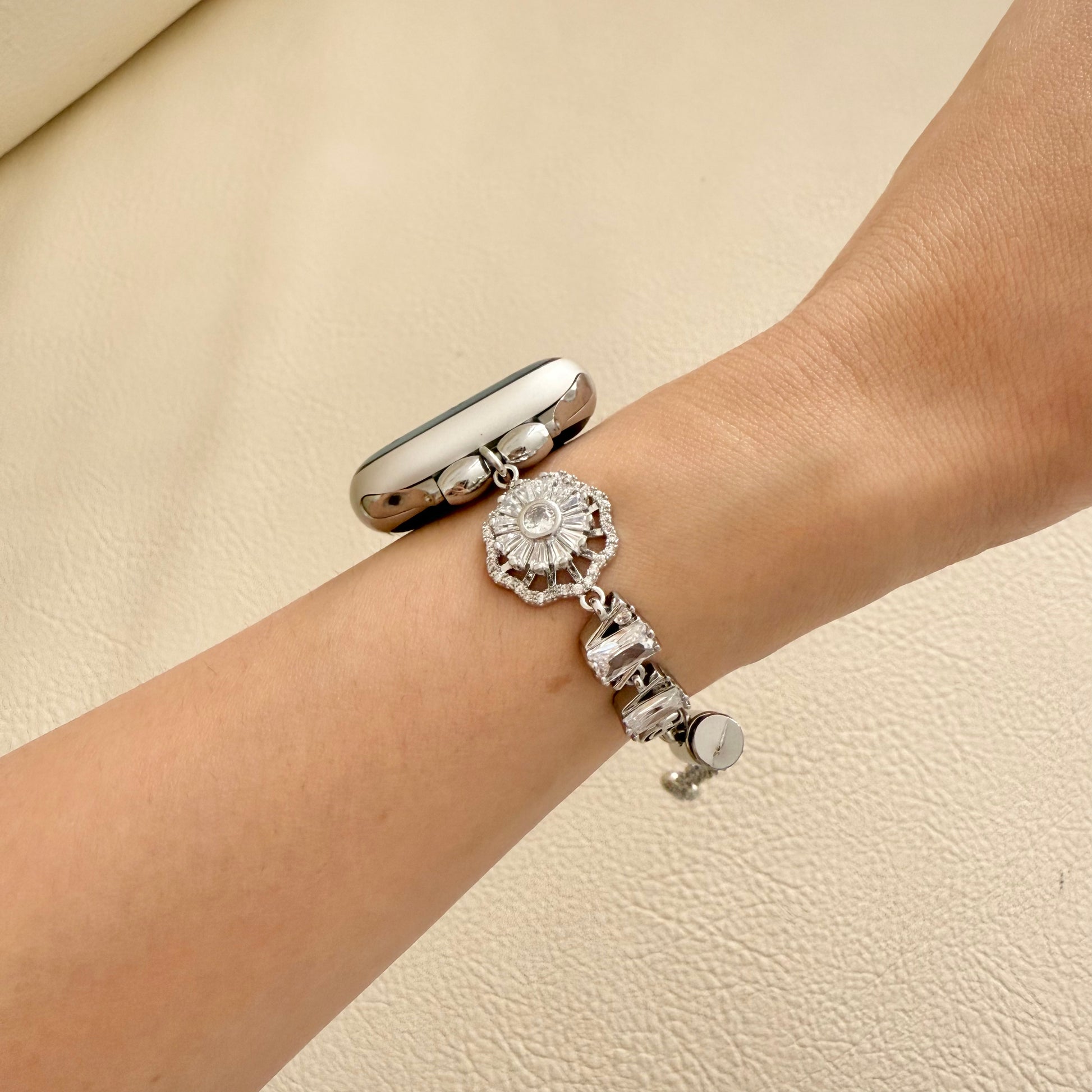 Silver apple watch bracelet with a decorative charm