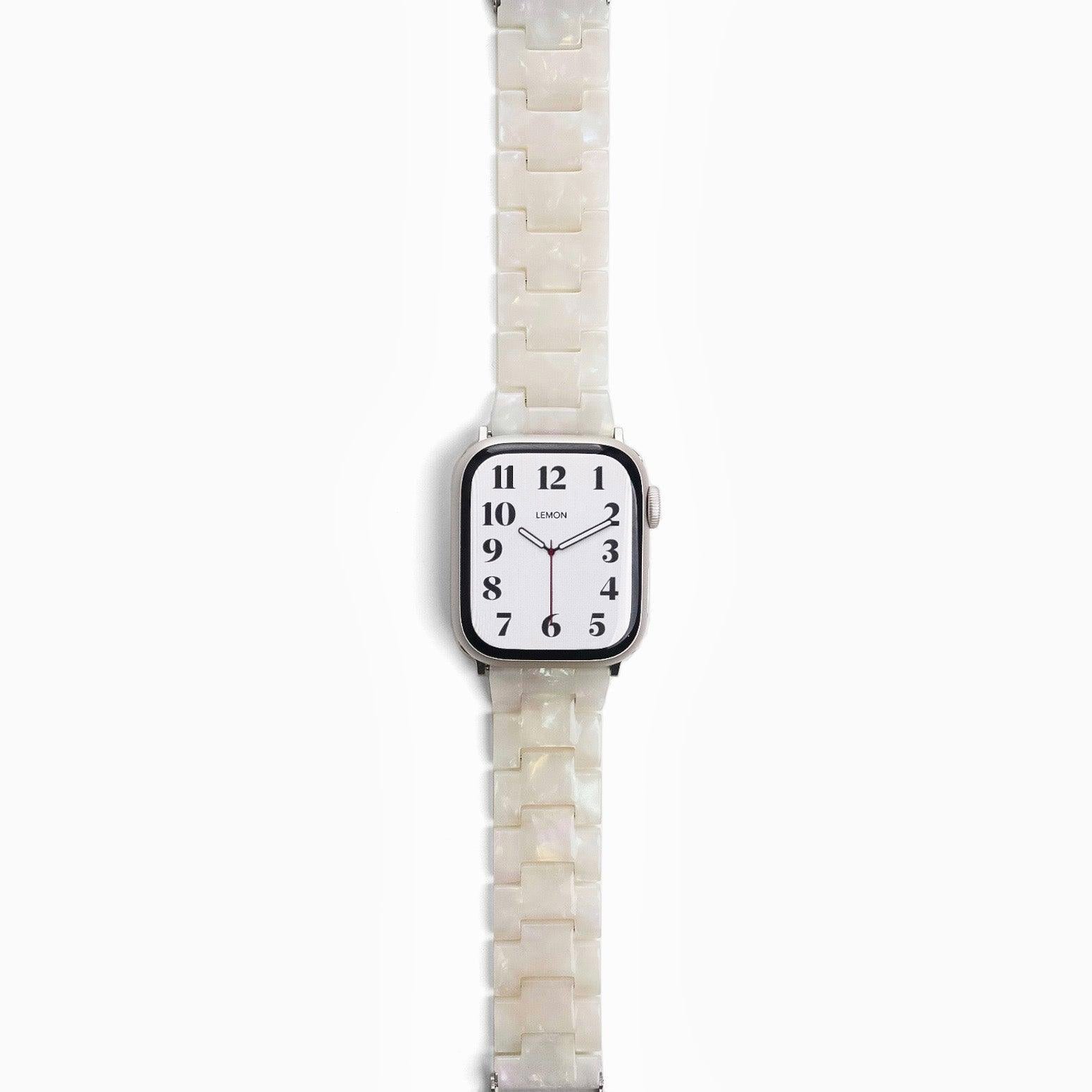 A pearl white resin band for Apple Watch, displayed on a watch with a silver case.