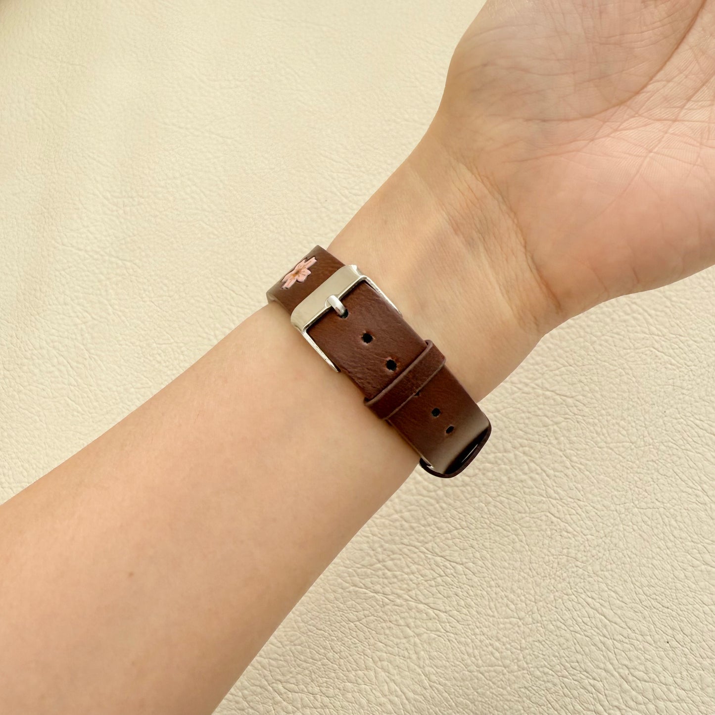 Brown sakura leather bracelet with silver clasp on a wrist 