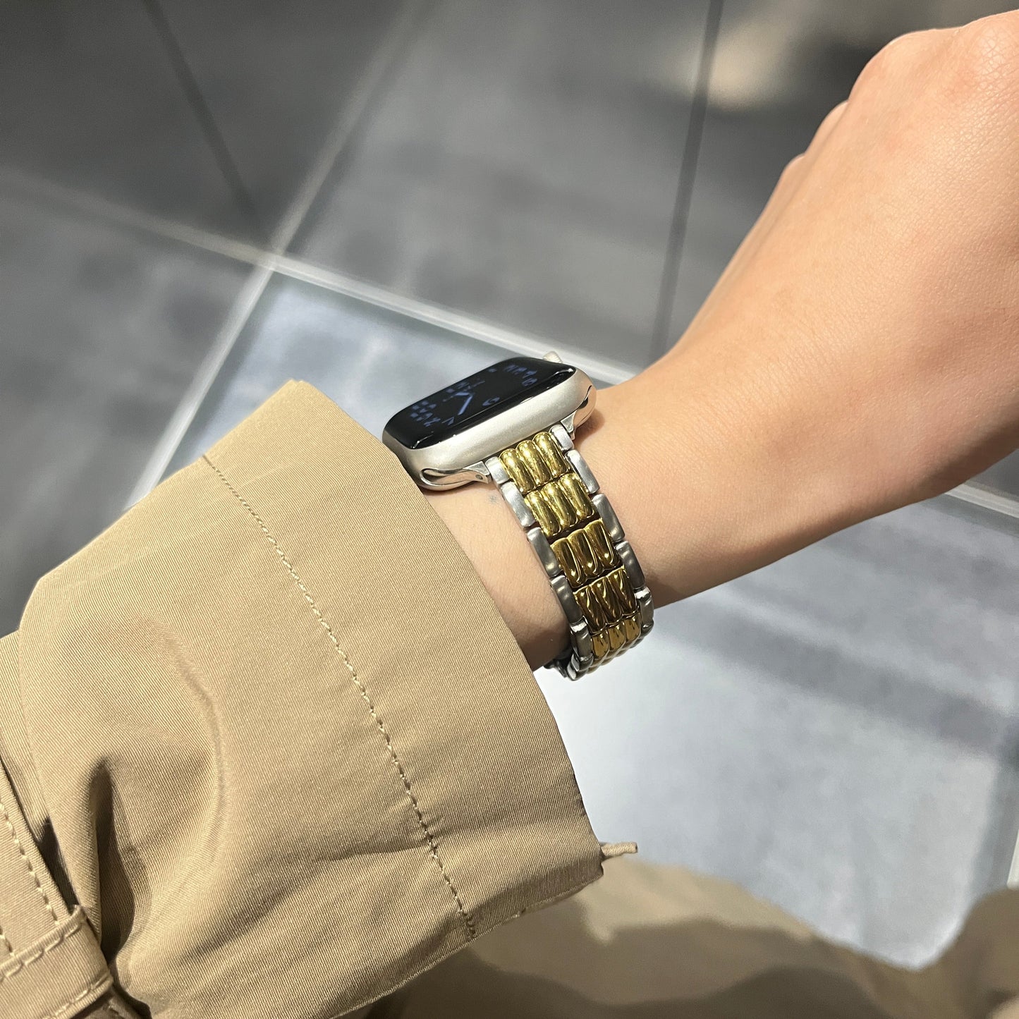 Close-up of a wrist wearing a gold APPLE watch strap