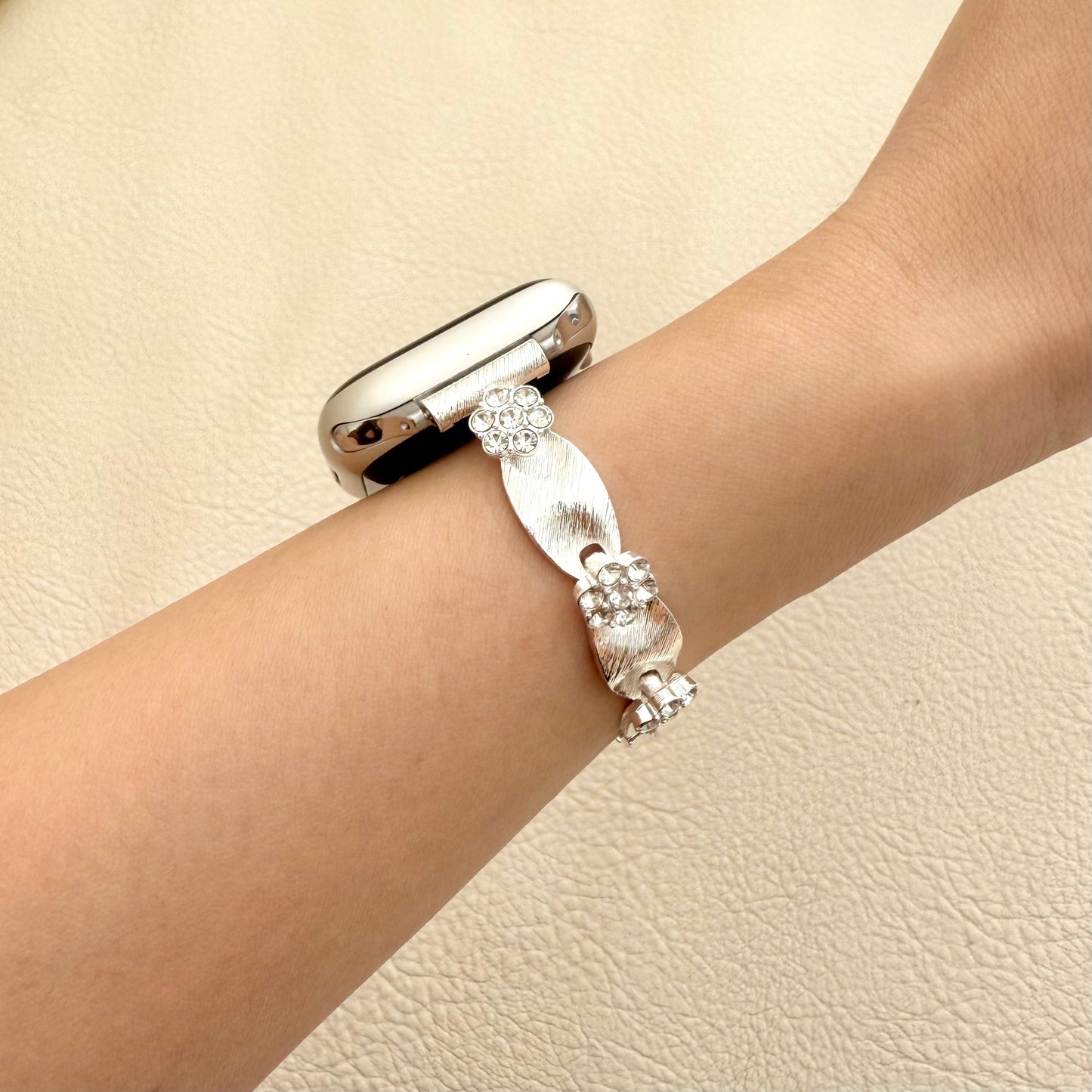 Silver APPLE WATCH bracelet with floral design on a wrist 